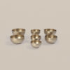 Seven hand-hammered note bowls from the Pure Bliss C4 Healing Bowl Set in a matte gold finish, arranged in varying sizes on a plain background.